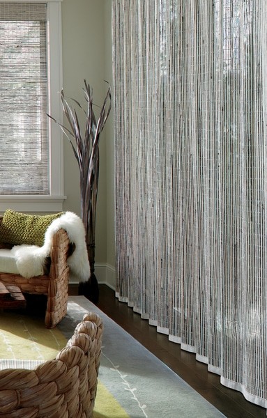 Natural Shade Drapery Woven — A vertical drapery for the patio door opening in ivory and misty grey offer elegance and beauty.
